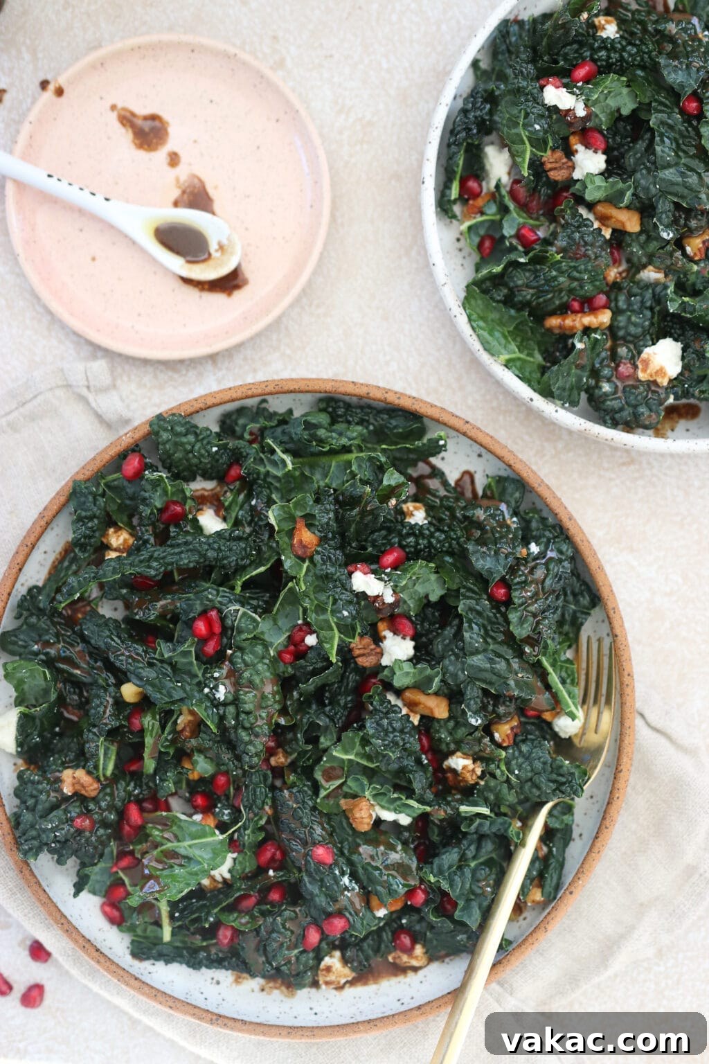 Two jars of prepped Kale Pomegranate Salad, ready for a week of healthy meals.