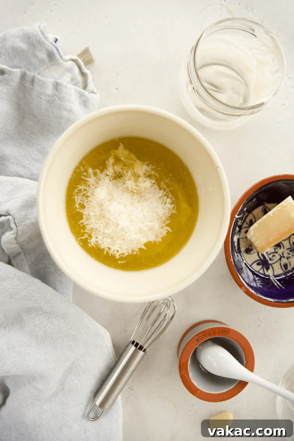 Effortless Creamy Greek Yogurt Caesar Dressing 4 A person adding plain Greek yogurt into a mason jar with other ingredients, symbolizing the first step of combining all dressing components.
