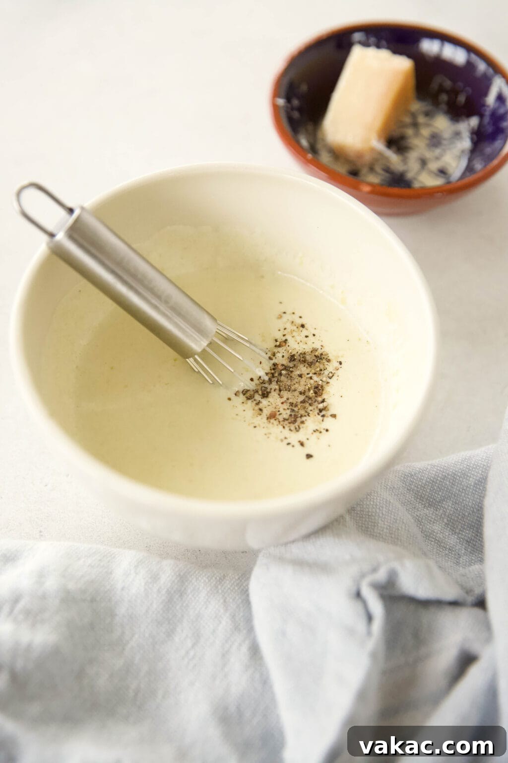 Effortless Creamy Greek Yogurt Caesar Dressing 5 A small whisk actively mixing ingredients in a mason jar, demonstrating the second step of whisking the Caesar dressing until smooth.