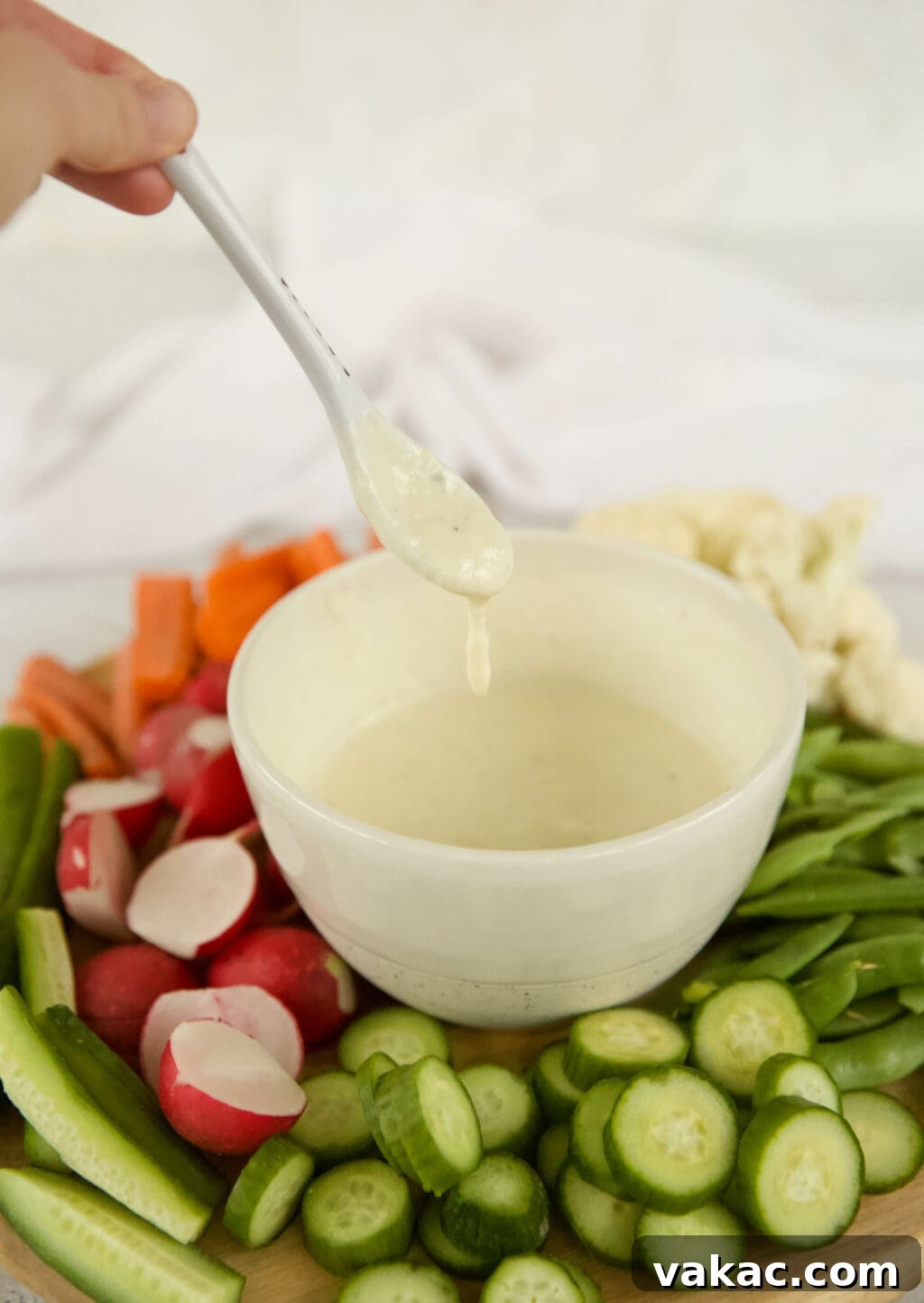 Effortless Creamy Greek Yogurt Caesar Dressing 6 The finished creamy Greek yogurt Caesar dressing served in a elegant white bowl on a wooden board, garnished with fresh herbs and a sprinkle of black pepper, ready to be enjoyed.