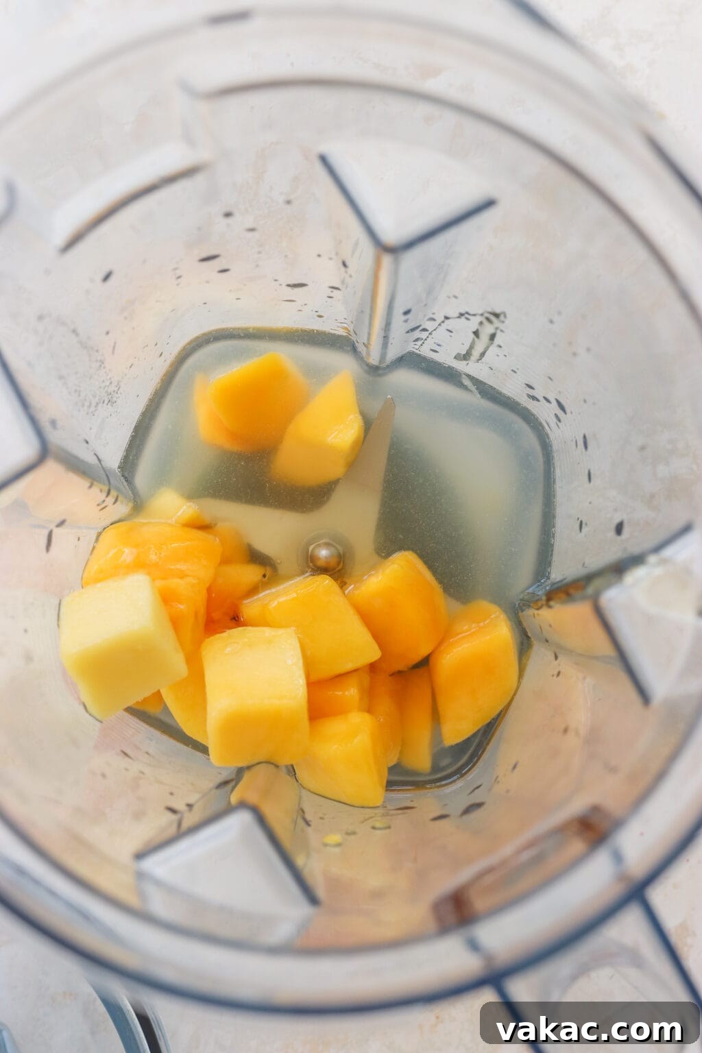 Effortless Wholesome Mango Puree 4 An overhead shot showing mango cubes, water, and lime juice inside a blender, ready to be processed.