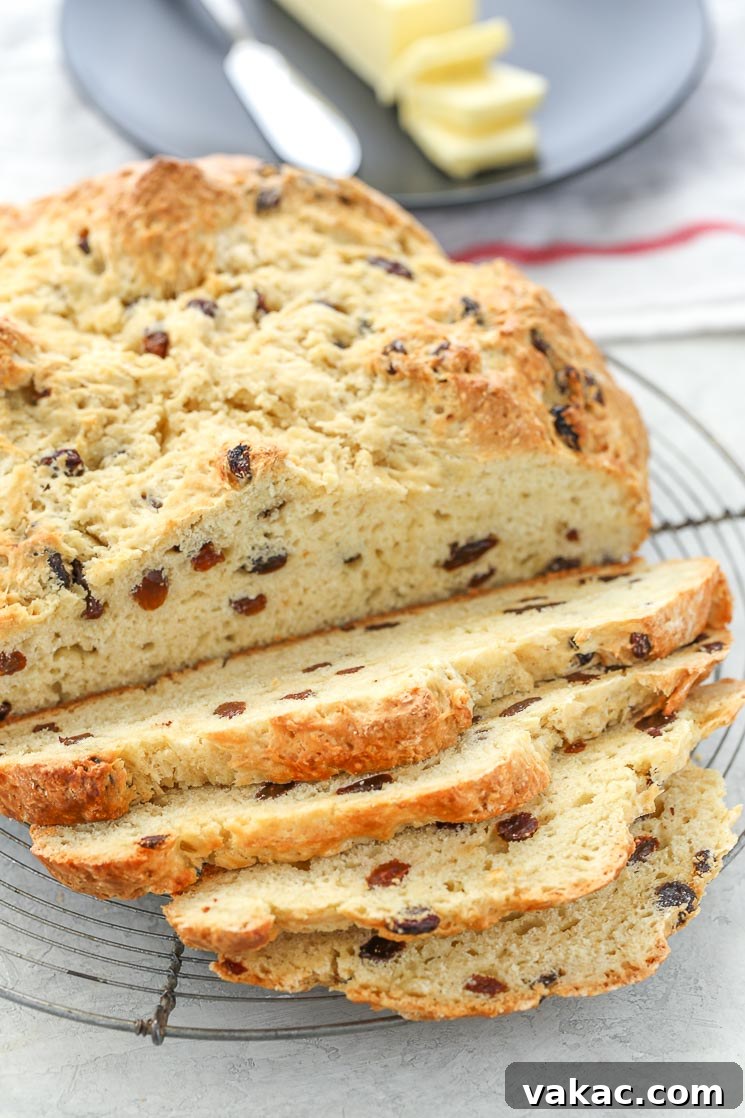 Traditional Irish Soda Bread 5 A sliced loaf of Irish Soda Bread on top of an antique round cooling rack with white and red napkin in the background.