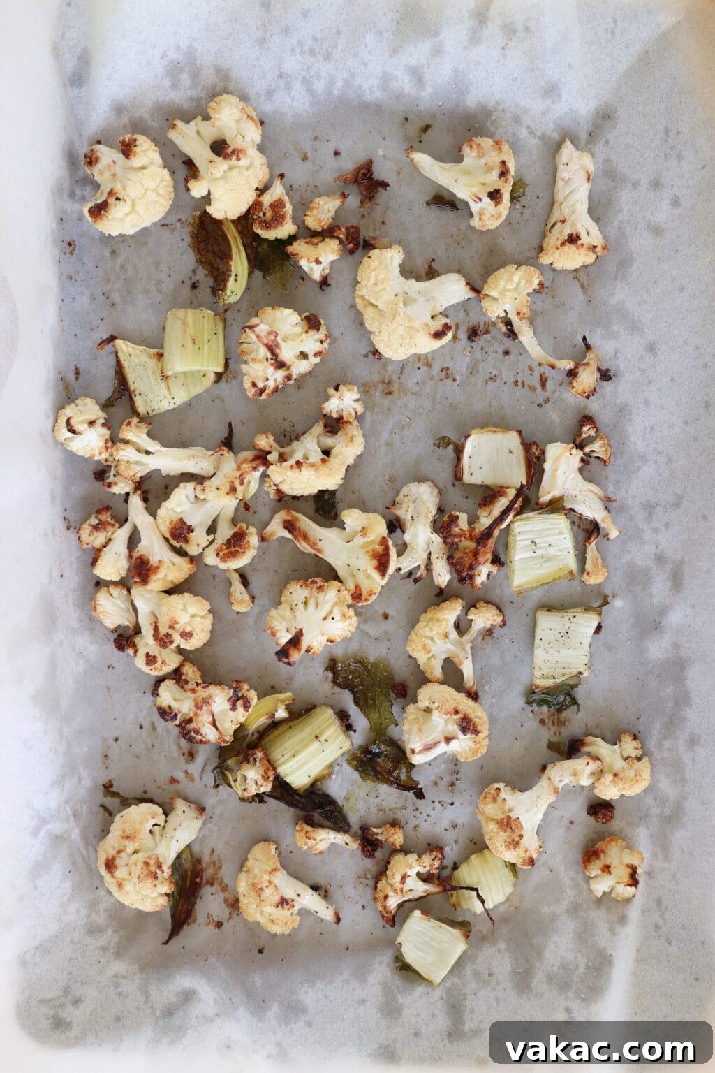 Meal Prep Magic Healthy Roasted Cauliflower Made Easy 6 A baking sheet has roasted cauliflower on it. The cauliflower is a nice mix of white and golden brown in color.