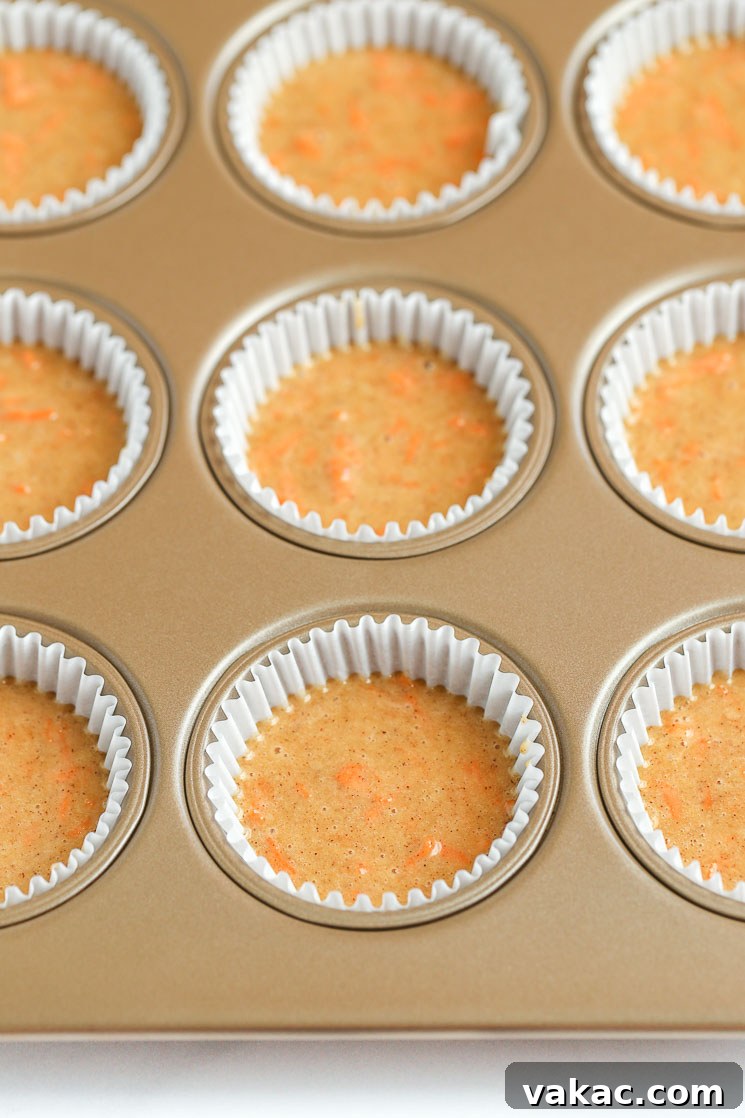 Spiced Carrot Cupcakes 4 A muffin pan filled with cupcake liners and carrot cake cupcake batter.