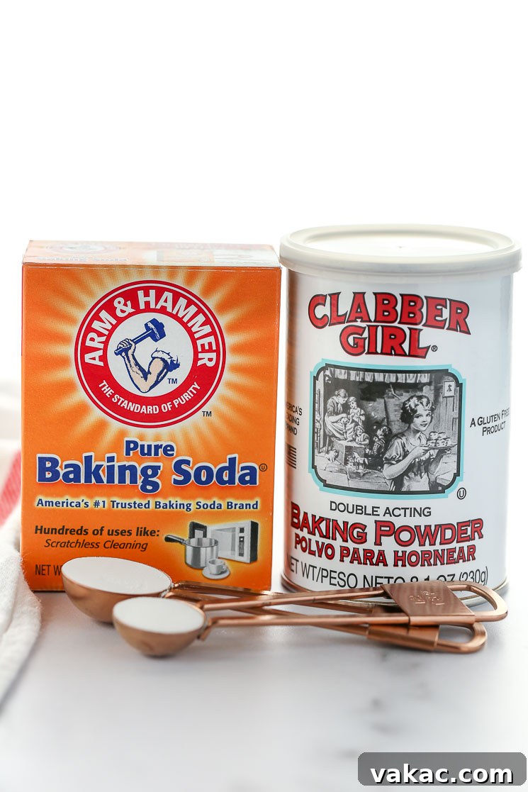 Kitchen Chemistry: Baking Soda vs. Baking Powder 2 A box of baking soda and can of baking powder on top of a marble surface.