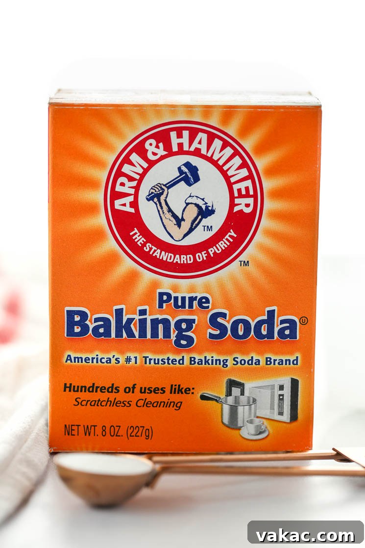 Kitchen Chemistry: Baking Soda vs. Baking Powder 3 A box of baking soda behind a measuring spoon on top of a marble surface.