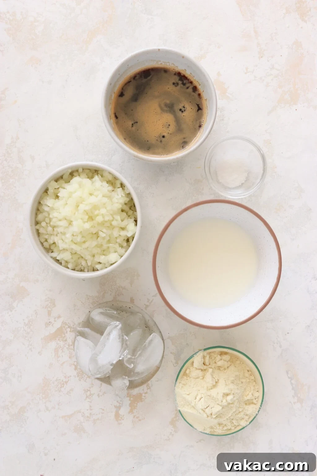 Protein Coffee Surge Smoothie 3 Recipe ingredients individually placed in small bowls including espresso, riced cauliflower, salt, milk, ice, and protein powder