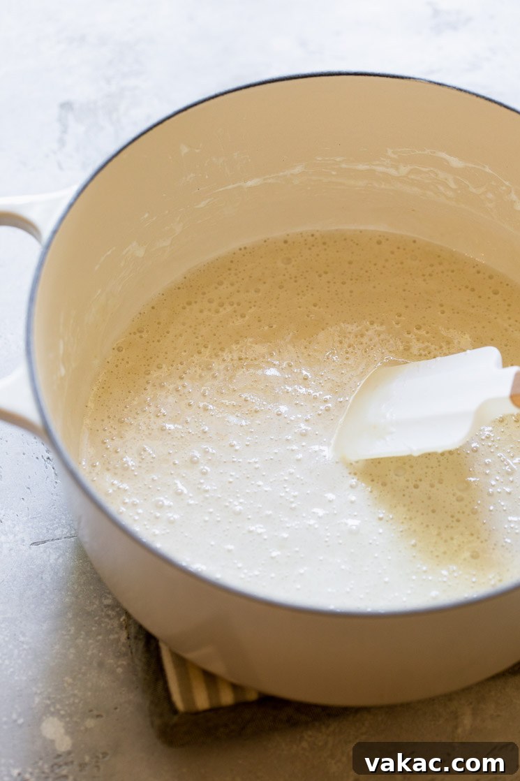 A Dutch oven with butter and marshmallows gently melting into a smooth, creamy mixture.