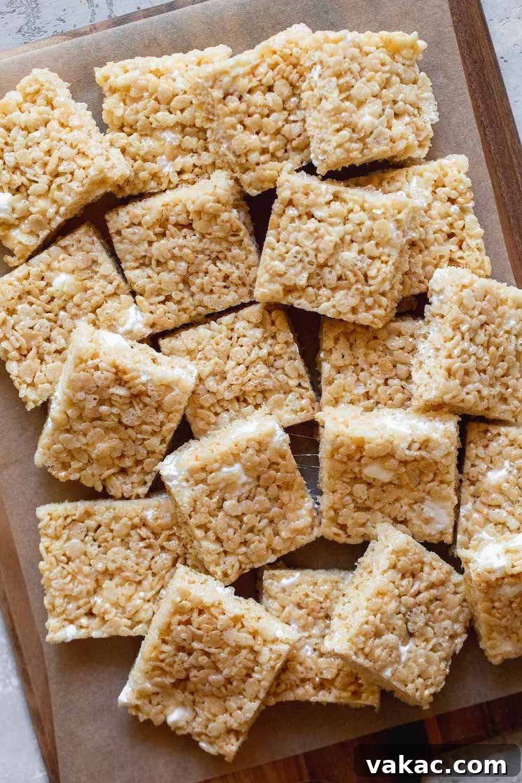 Multiple squares of soft, chewy Rice Krispie Treats artfully arranged on a wooden tray, ready for serving.