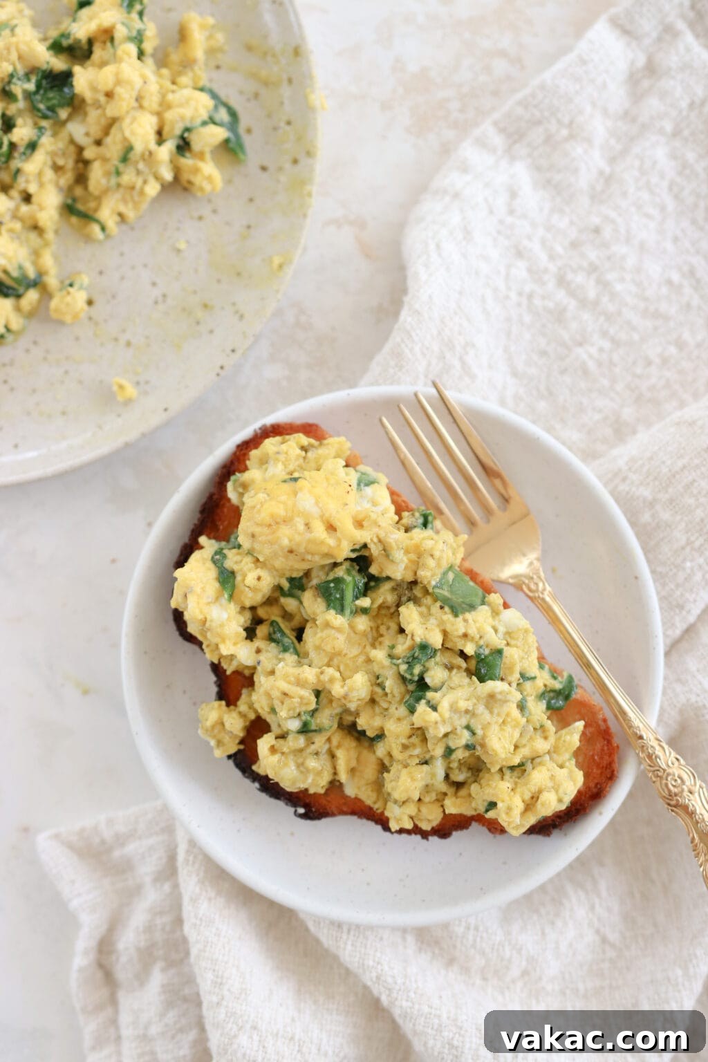 Dreamy 10-Minute Cottage Cheese Scramble 2 A slice of golden toast generously topped with perfectly cooked spinach and pesto cottage cheese scrambled eggs.