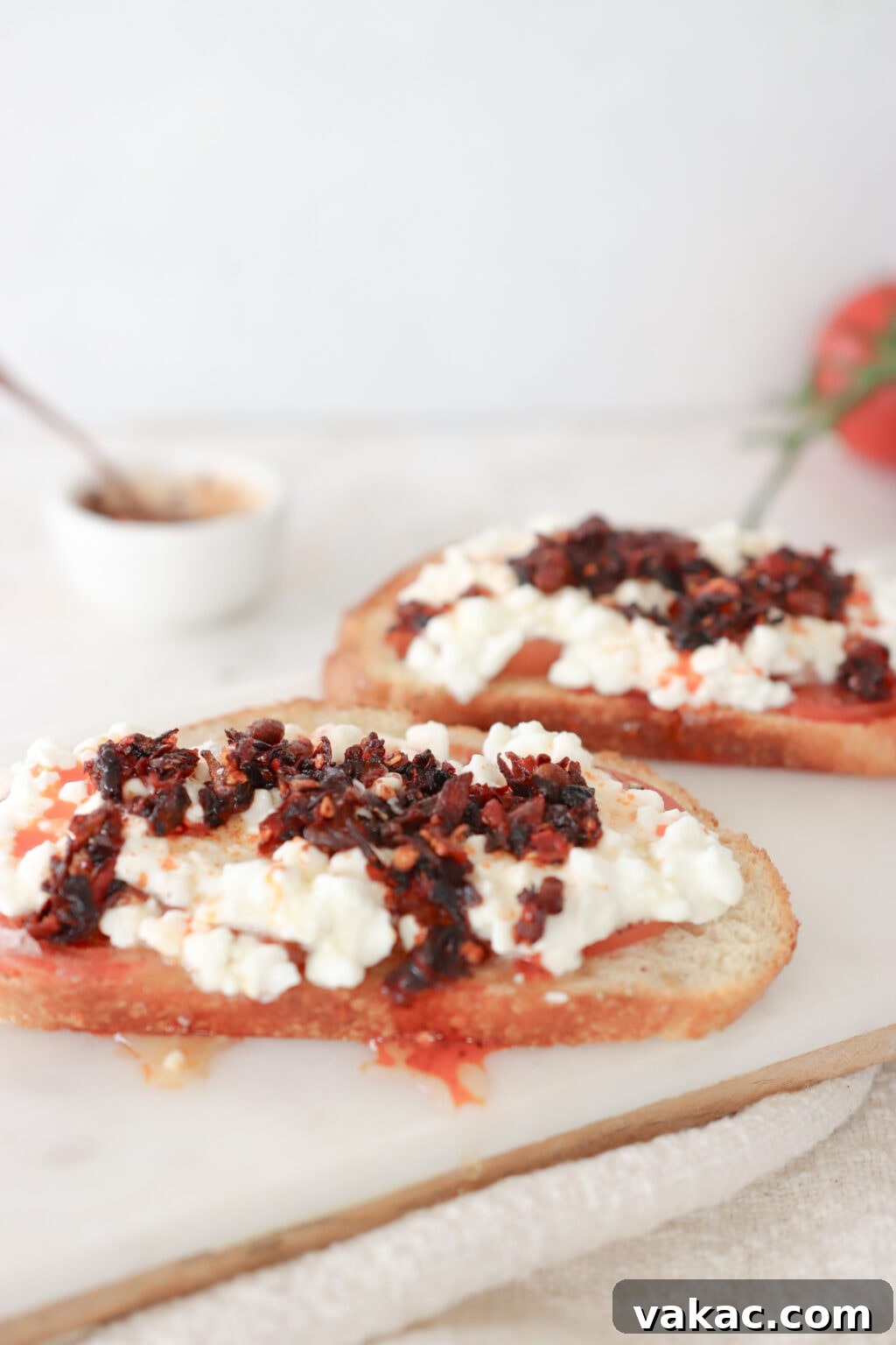 2 pieces of cottage cheese toast topped with chilic crisp oil and honey on a marble cutting board