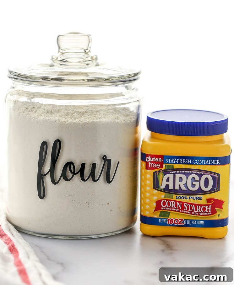 A container of cake flour and cornstarch sitting on top of a marble surface.