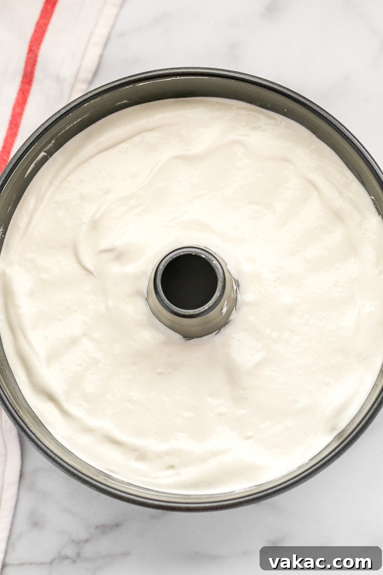 Heavenly Cloud Cake 5 An ungreased angel food cake pan filled with light and airy cake batter, ready for baking.