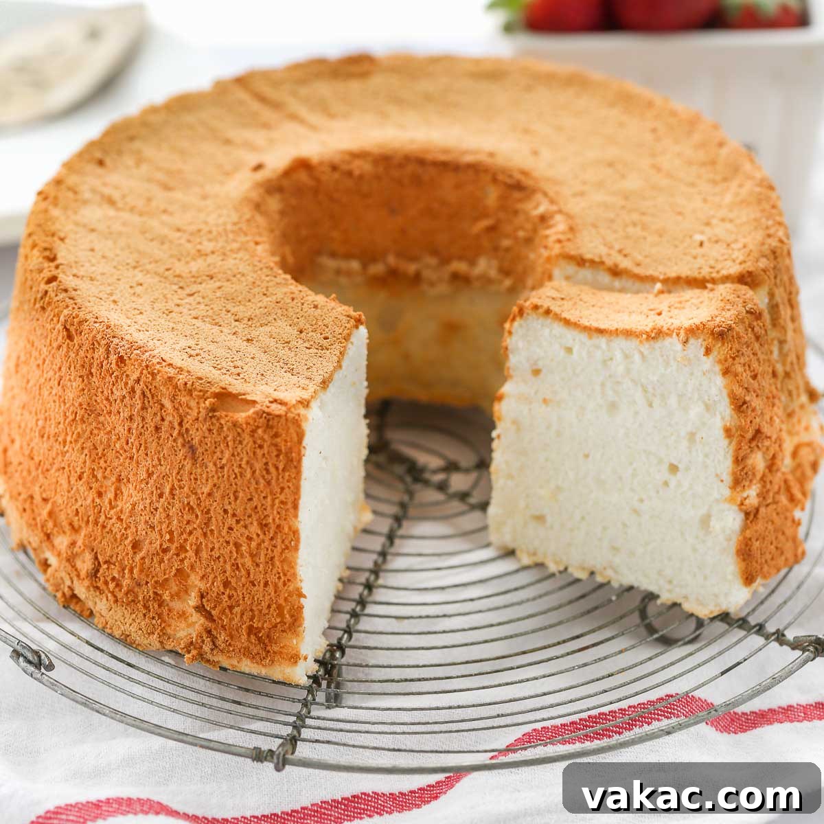 Heavenly Cloud Cake 7 An angel food cake sitting on top of a wire rack, ready to be served.