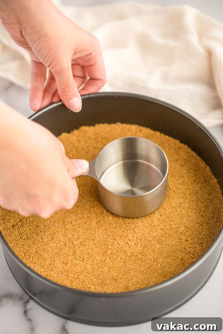 Grandma's Classic Cheesecake 3 A springform pan filled with an unbaked graham cracker crust.