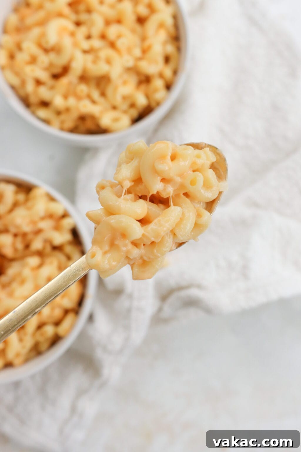 Secretly Creamy 5-Ingredient Cottage Cheese Mac 8 5 Ingredient Creamy Cottage Cheese Mac and Cheese in two white bowls with a scoop displayed in a spoon.