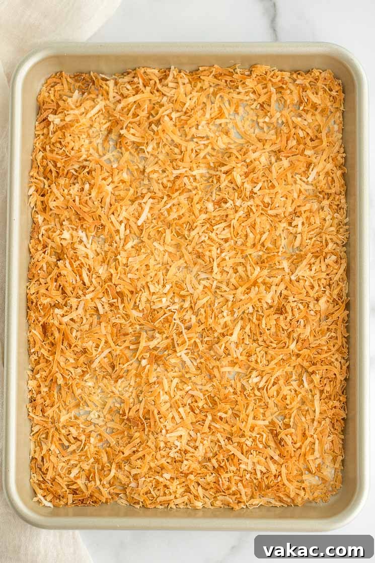 Secrets to Perfectly Toasted Coconut 3 A batch of toasted coconut spread out onto a baking sheet.