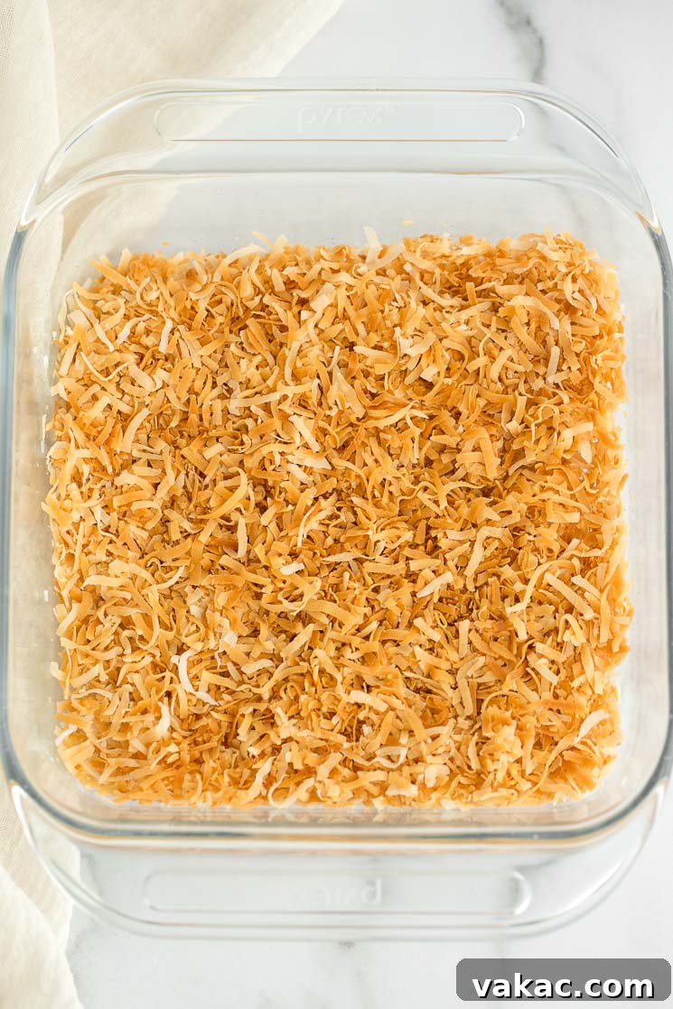 Secrets to Perfectly Toasted Coconut 4 A glass baking dish with toasted coconut covering the bottom.