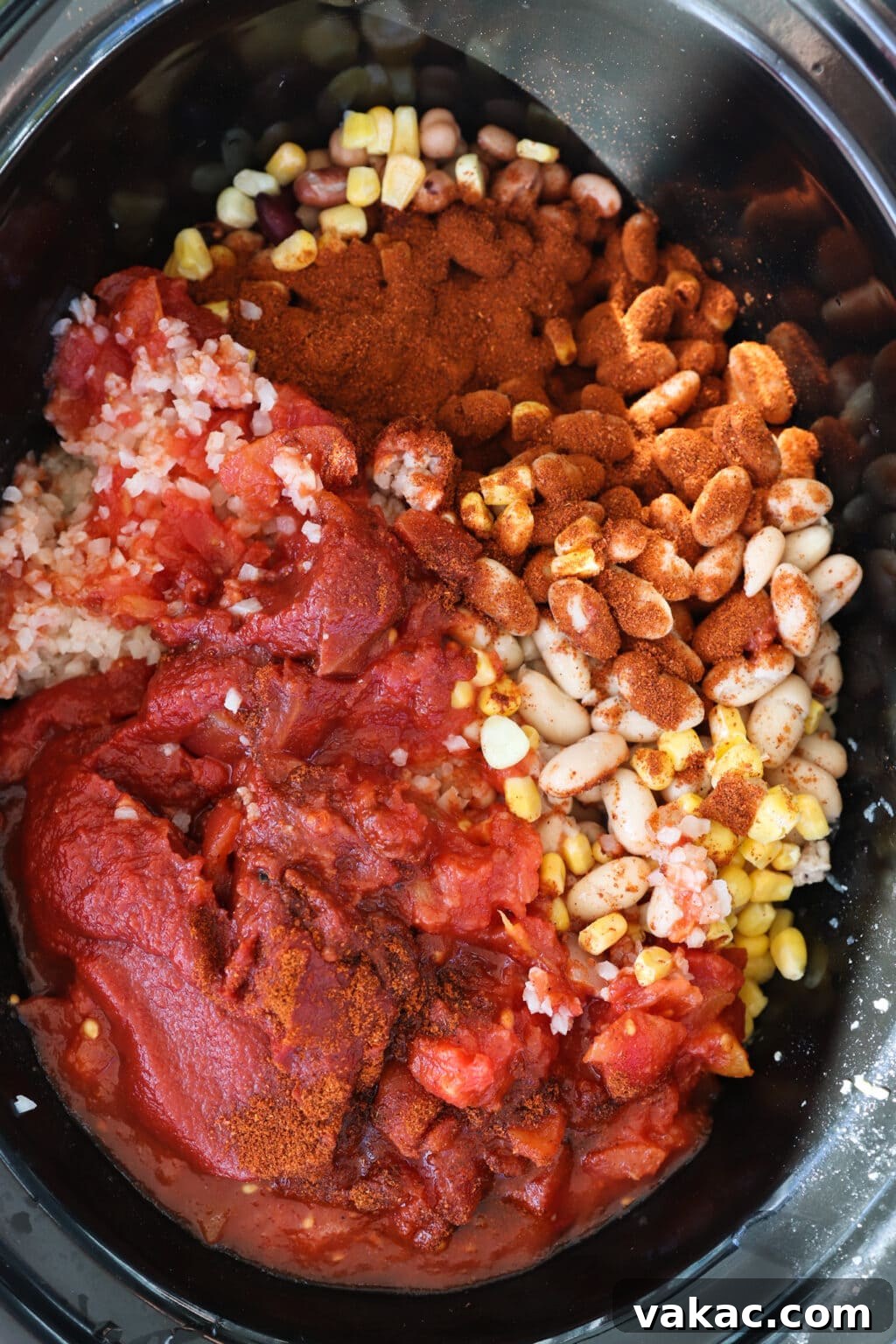Comforting Slow Cooker Sweet Potato and Turkey Chili 5 All chili ingredients, including browned ground turkey, roasted sweet potatoes, diced onions, corn, garlic, sliced mushrooms, diced tomatoes, tomato paste, mixed beans, kidney beans, and cauliflower rice, assembled in a slow cooker.