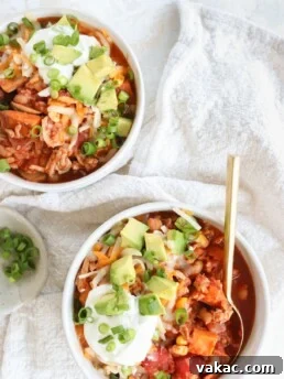 Slow Cooker Sweet Potato & Turkey Chili in two white bowls on a white table cloth