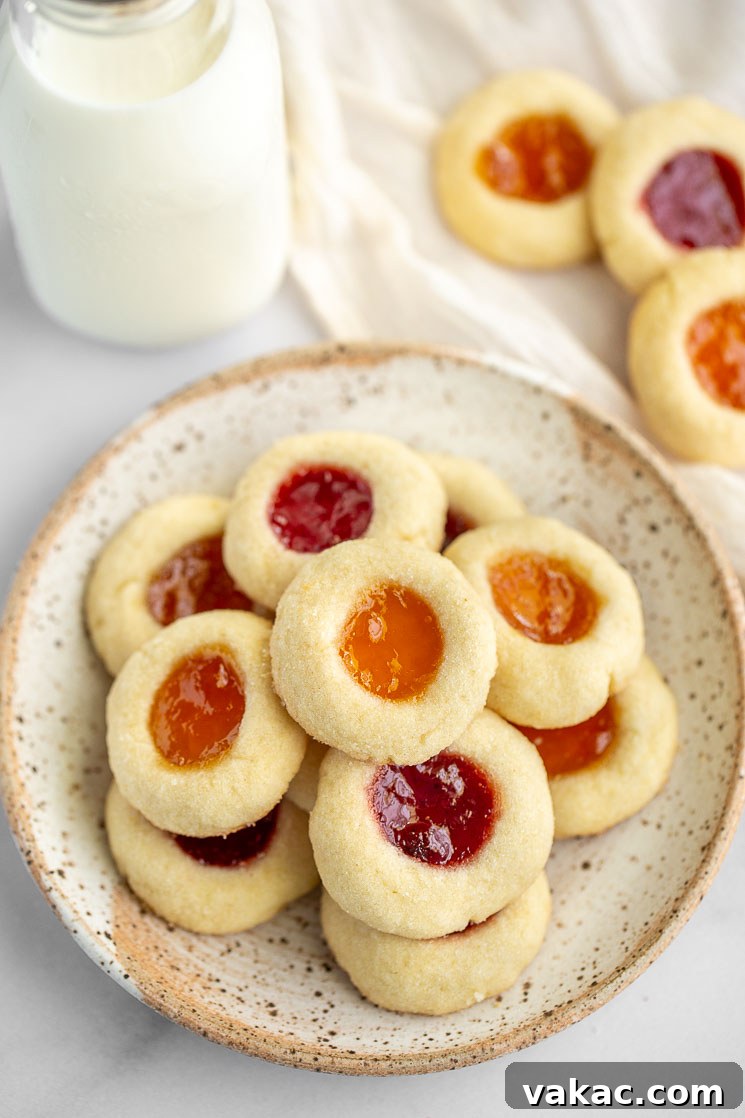 Sweet Impressions 2 An speckled plate filled with thumbprint cookies with more cookies and milk behind it.