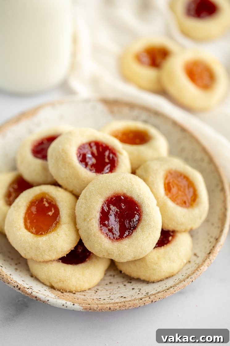 Sweet Impressions 5 Thumbprint cookies sitting on top of a speckled place with more cookies behind it.