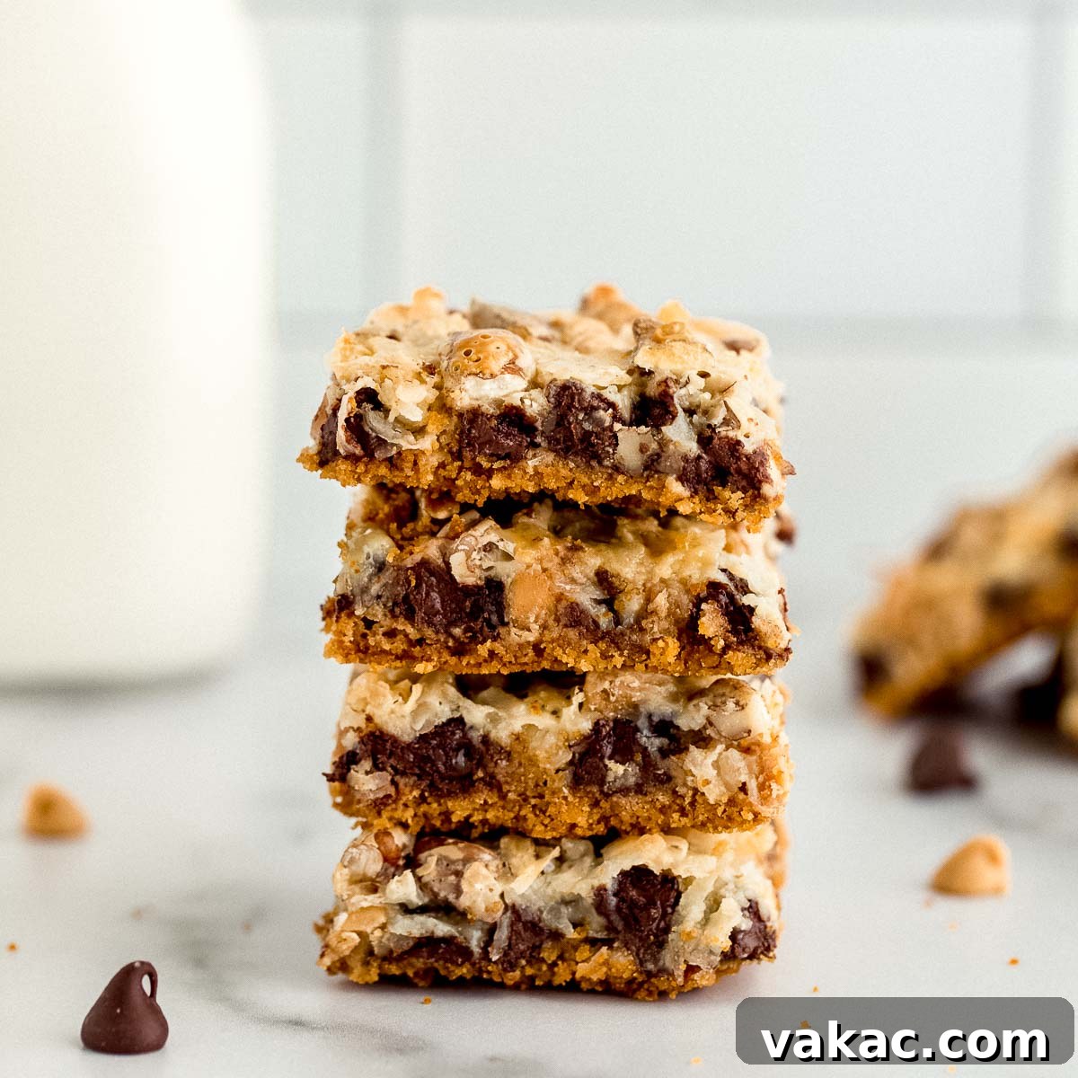 Ultimate Layered Indulgence 6 A stack of golden brown magic cookie bars on a clean marble surface, ready to be served.