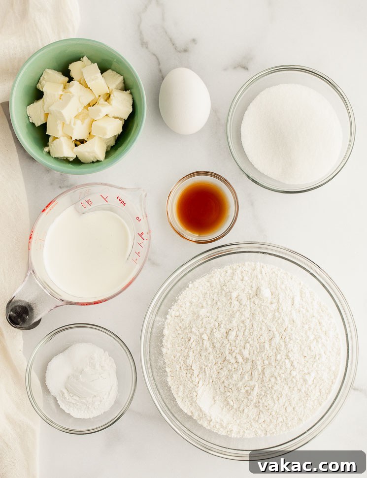 Perfectly Fluffy Scones 3 All the essential ingredients for making perfect scones are meticulously measured out and displayed in individual glass bowls on a sleek marble surface, highlighting readiness for baking.