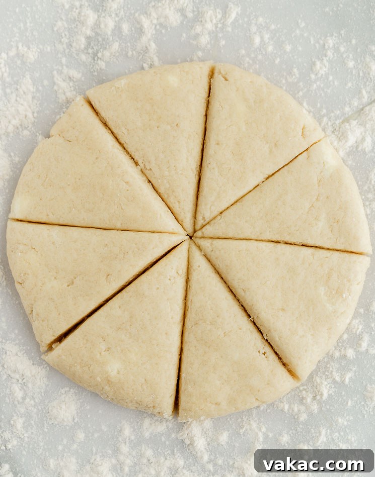 Perfectly Fluffy Scones 5 Perfectly cut portions of scone dough are arranged evenly on a lightly floured surface, ready for the next step in the baking process, highlighting precision and preparation.