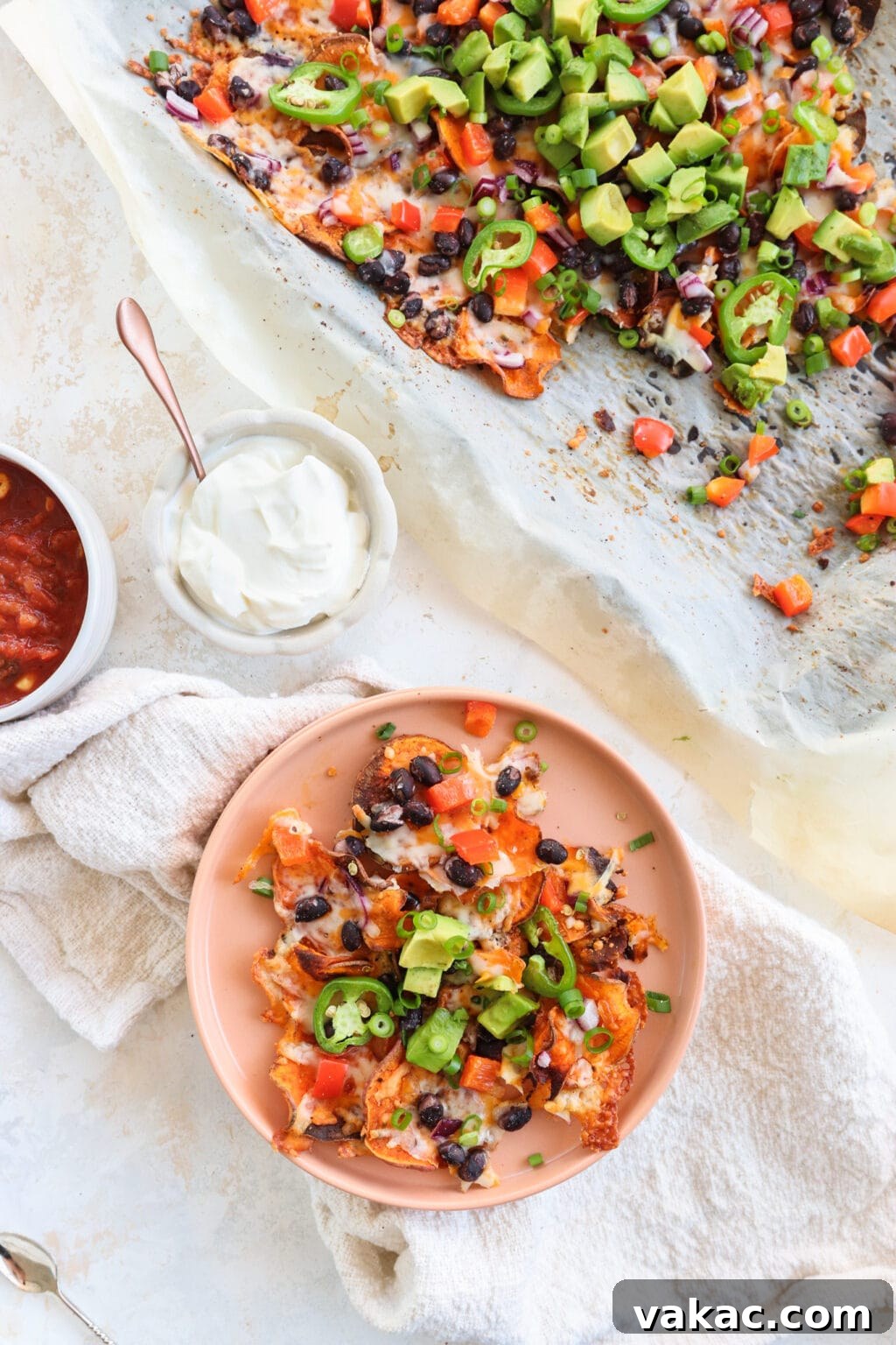 Healthy Sweet Potato Nachos with Black Beans and Bell Peppers 2 Healthy Black Bean & Bell Pepper Sweet Potato Nachos on a pink plate with salsa and sour cream