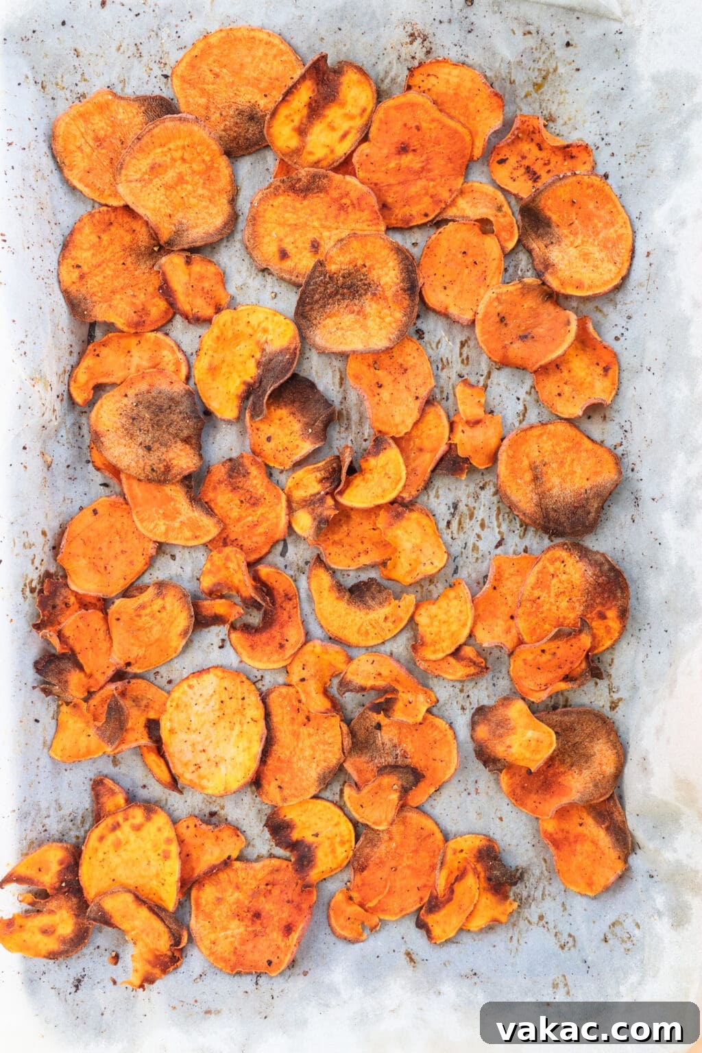 Healthy Sweet Potato Nachos with Black Beans and Bell Peppers 4 Cooked sweet potato chips on a baking sheet with parchment paper