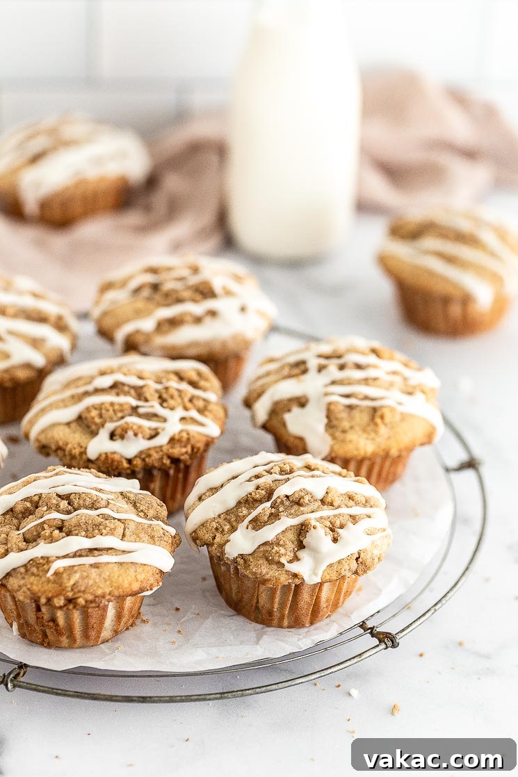 Homemade Apple Delights 3 Glazed apple muffins displayed beautifully on a round wire rack, glistening with vanilla icing.