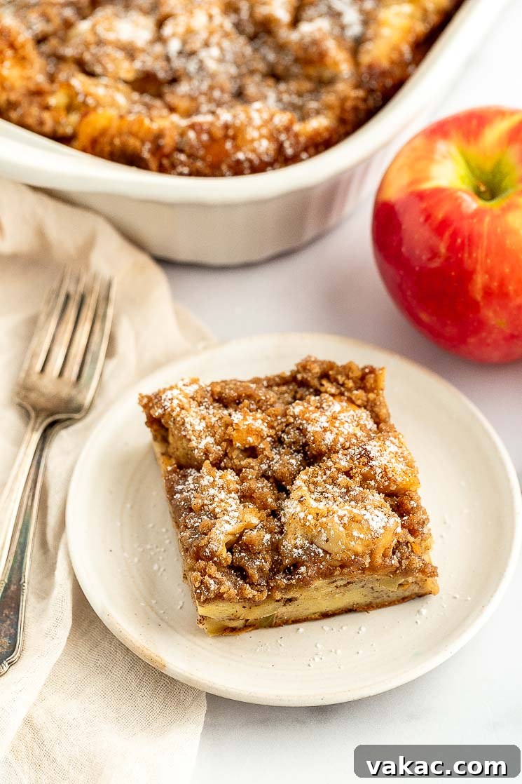 Cinnamon Apple Streusel French Toast Bake 6 A perfectly portioned slice of apple streusel french toast casserole on a white plate, ready to be enjoyed.