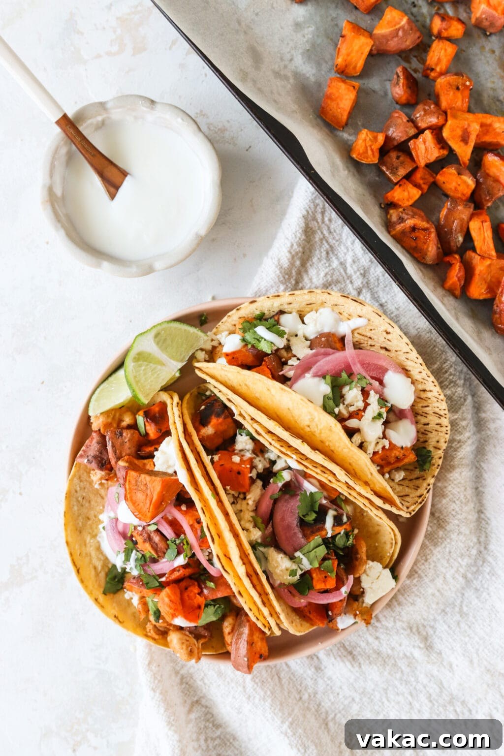 Make-Ahead Cajun Roasted White Beans 6 Meal prep roasted sweet potatoes on a plate of roasted white bean and sweet potato tacos with lime crema and fixings on the side