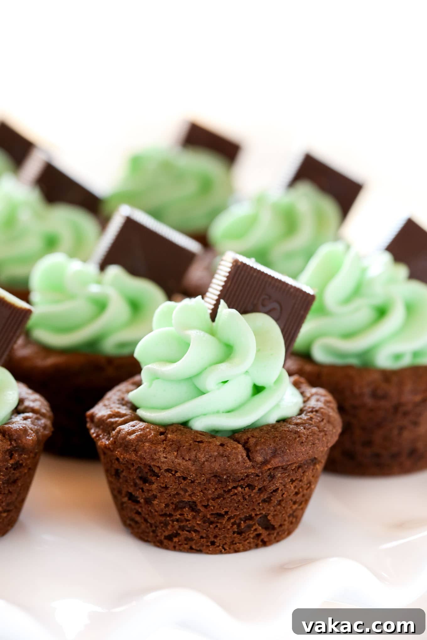 Refreshing Mint Chocolate Cookie Cups 2 Mint Chocolate Cookie Cups displayed on a cooling rack, showcasing their perfect chocolate base and awaiting frosting.