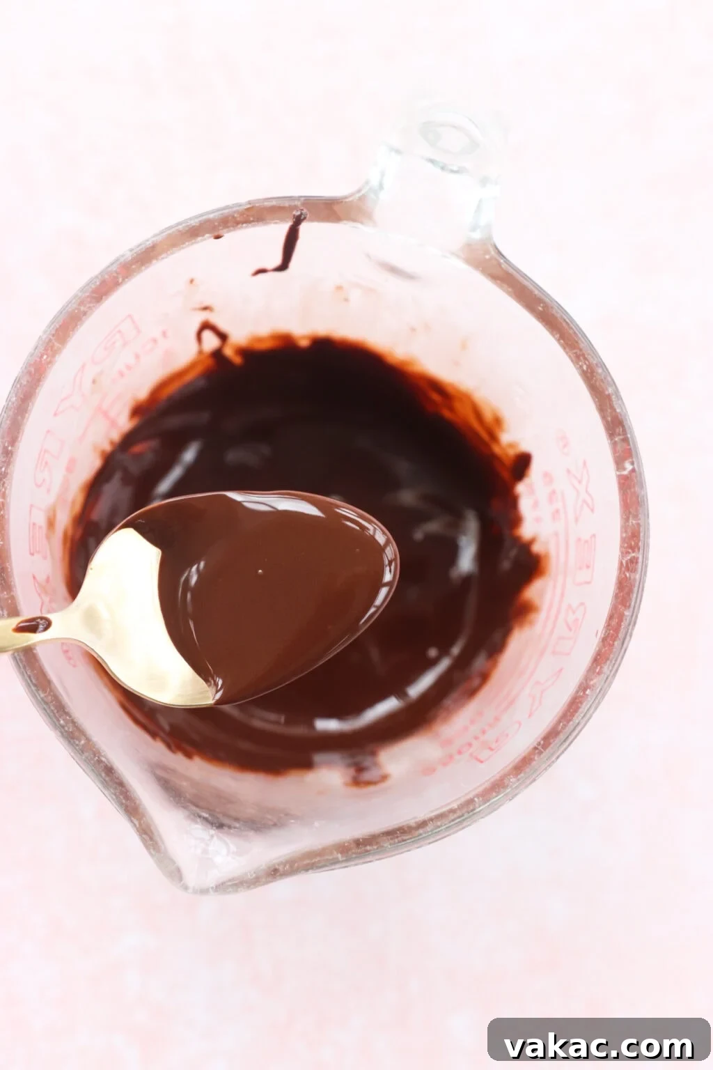 Creamy Peanut Butter and Greek Yogurt Cups with Chocolate Crunch 7 Ingredients for Peanut Butter & Greek Yogurt Cups with Magic Chocolate Shell mixed in a glass measuring cup on a pink marble counter, including chocolate and coconut oil