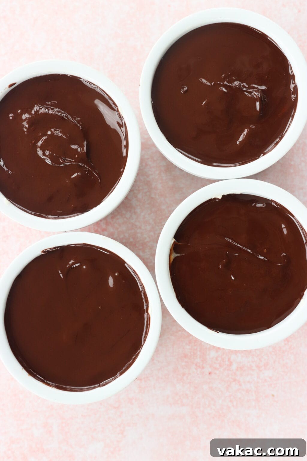 Creamy Peanut Butter and Greek Yogurt Cups with Chocolate Crunch 8 Peanut Butter & Greek Yogurt Cups with Magic Chocolate Shell in four white bowls on a pink marble countertop