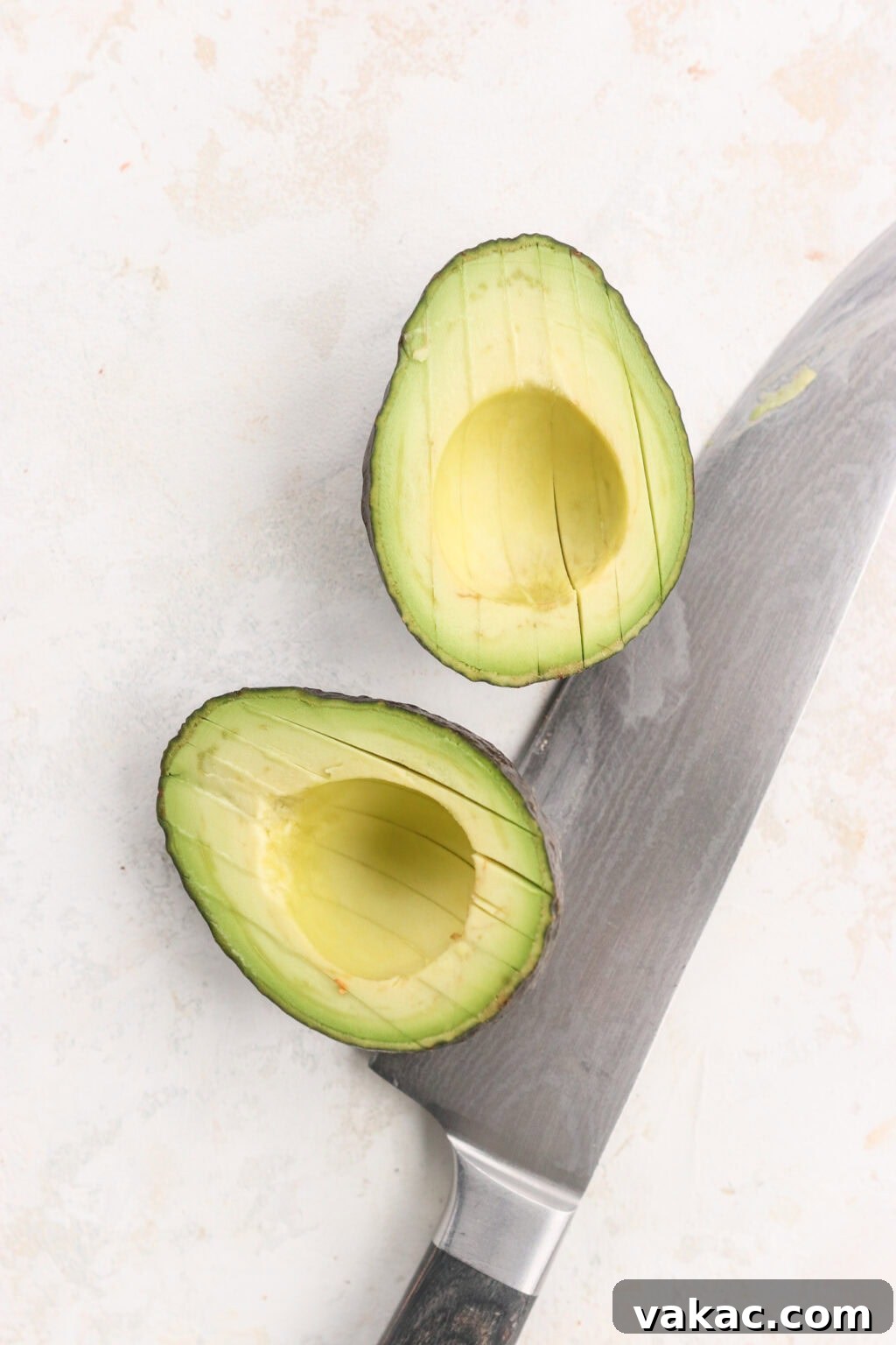 Rapid Tangy Avocados from the Jar 4 A perfectly firm avocado cut in half, with a sharp knife beside it, illustrating the ideal ripeness for pickling
