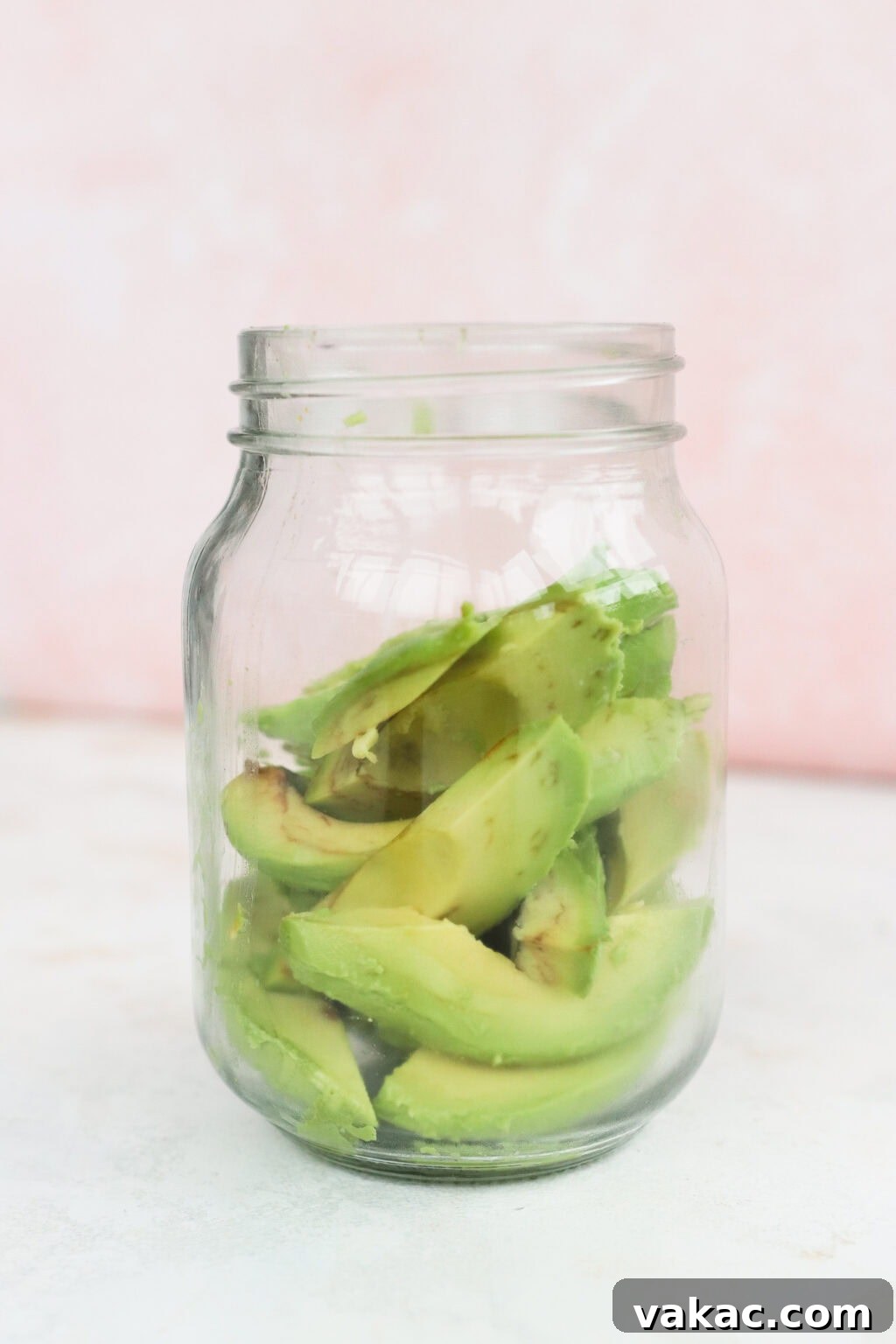Rapid Tangy Avocados from the Jar 5 Freshly sliced avocado pieces being carefully placed into a clean glass mason jar, ready for the pickling brine