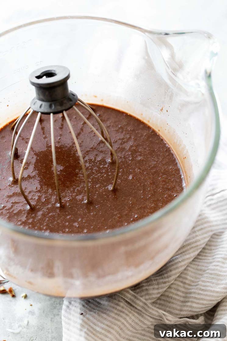 Signature German Chocolate Creation 3 A glass mixing bowl filled with chocolate cake batter with the whisk still in the bowl.