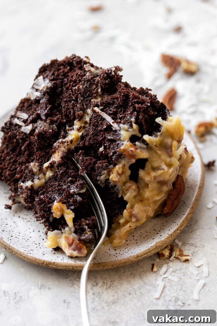 Signature German Chocolate Creation 6 A slice of German Chocolate Cake on a rustic clay plate with a fork cutting off a piece to take a bite.