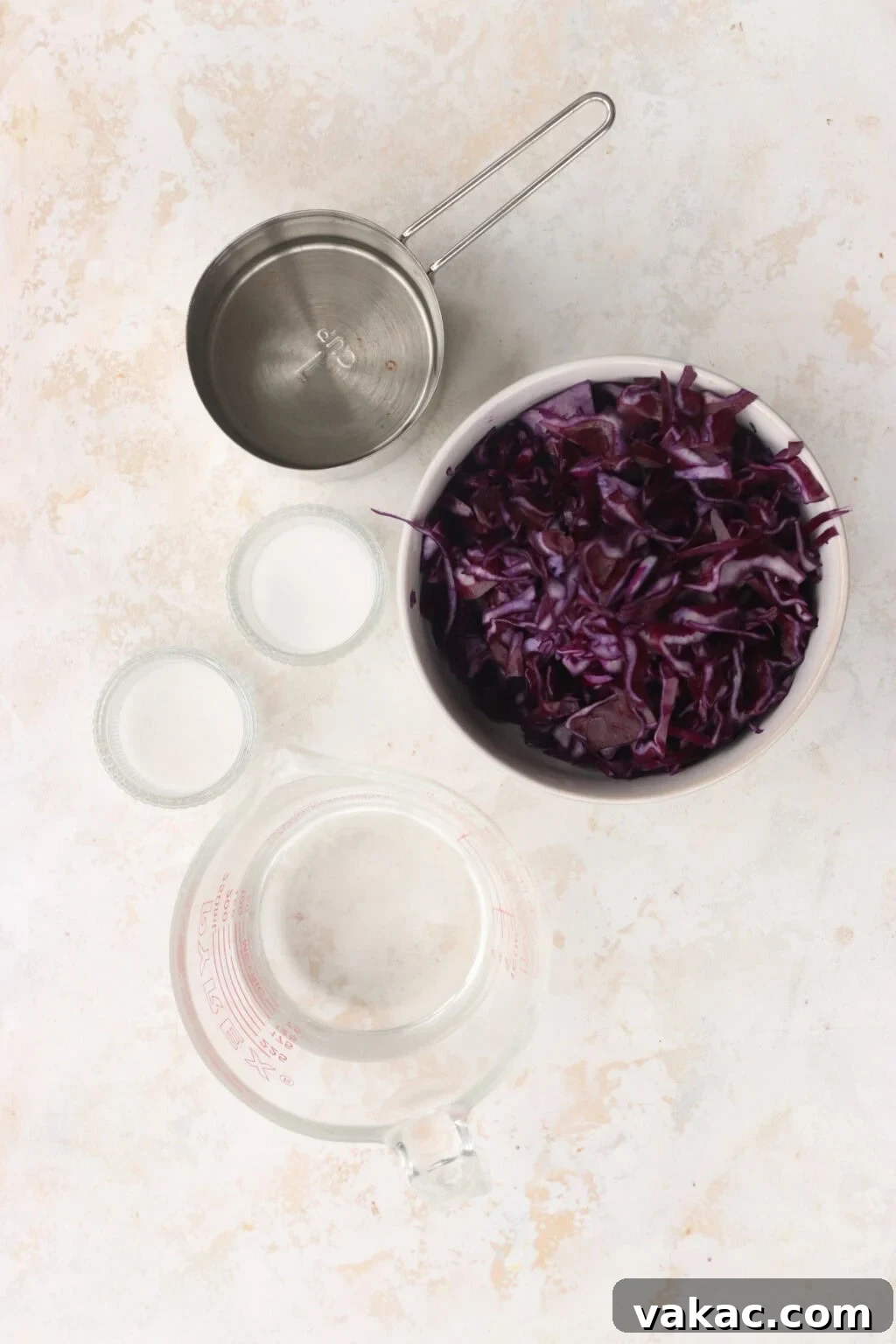 Quick Pickled Red Cabbage Made Easy 3 Ingredients for quick pickled red cabbage, including shredded red cabbage, sugar, salt, vinegar, and water, laid out on a clean surface