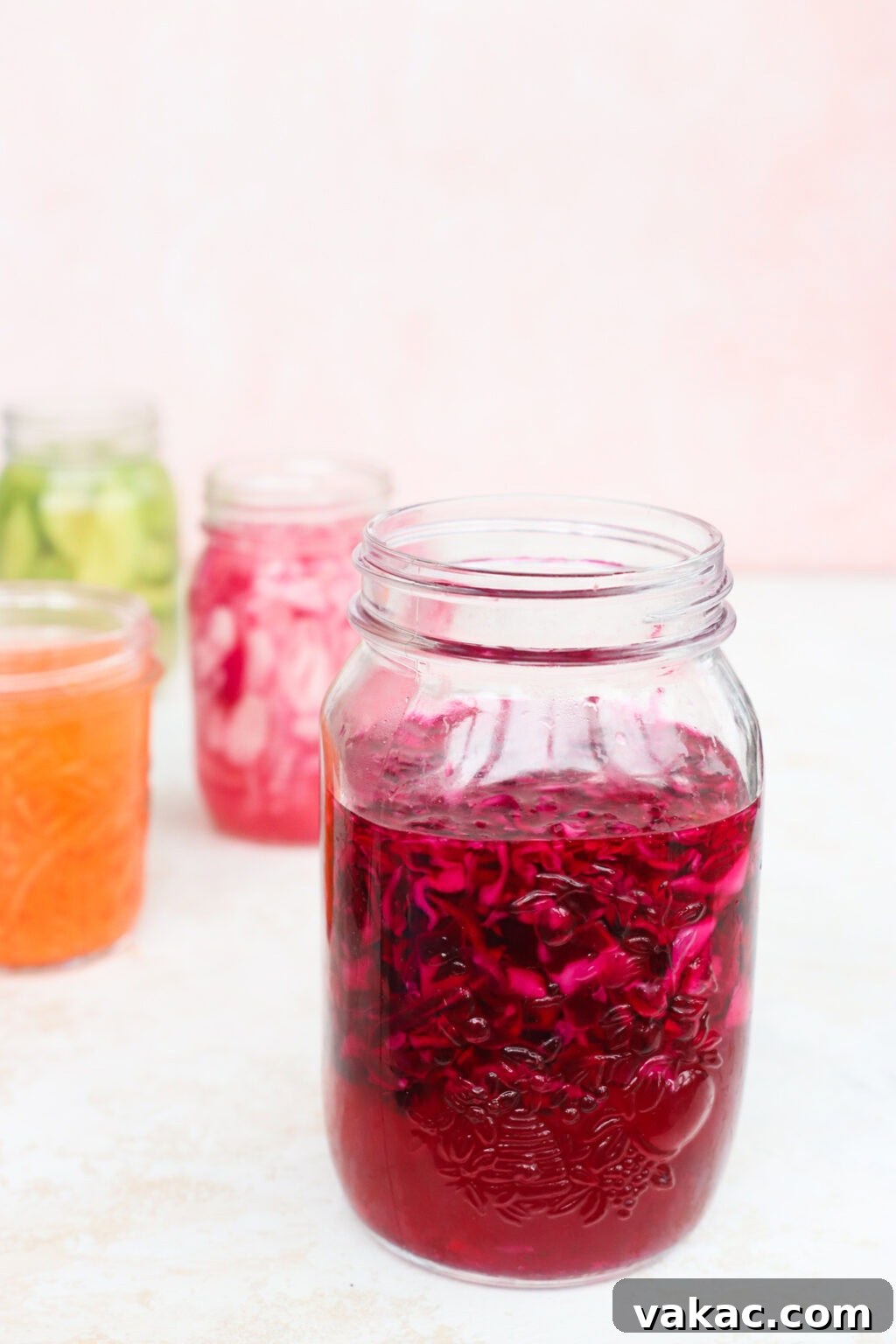 Quick Pickled Red Cabbage Made Easy 7 Several glass jars of quick pickled shredded carrots, red cabbage, avocados, and red onion, cooling on a countertop