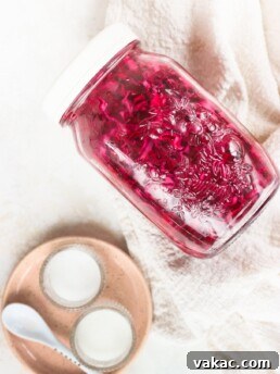 Quick pickled red cabbage in a glass jar with a pink plate beside it