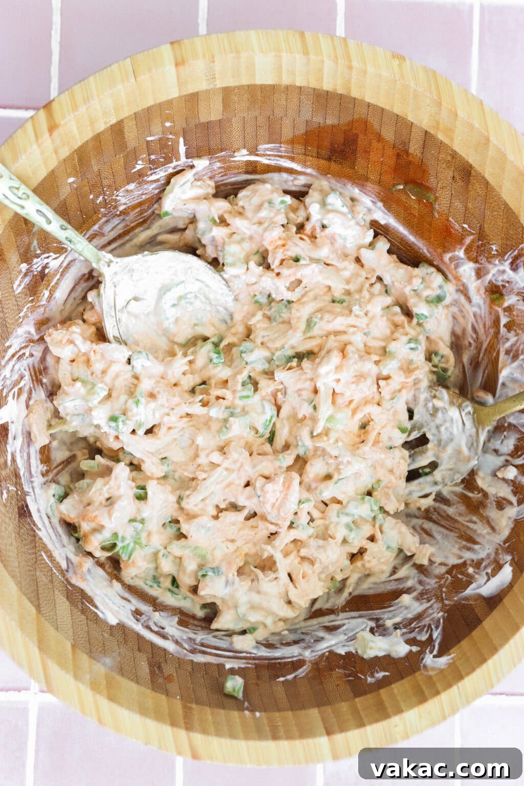 Fast Protein-Packed Buffalo Chicken Salad with Greek Yogurt 5 Ingredients for Quick Buffalo Chicken Salad with Greek Yogurt mixed in a medium wooden bowl including cooked shredded chicken, Greek yogurt, mayo, Frank's Red Hot Original Sauce, garlic powder, green onions, blue cheese, pepper