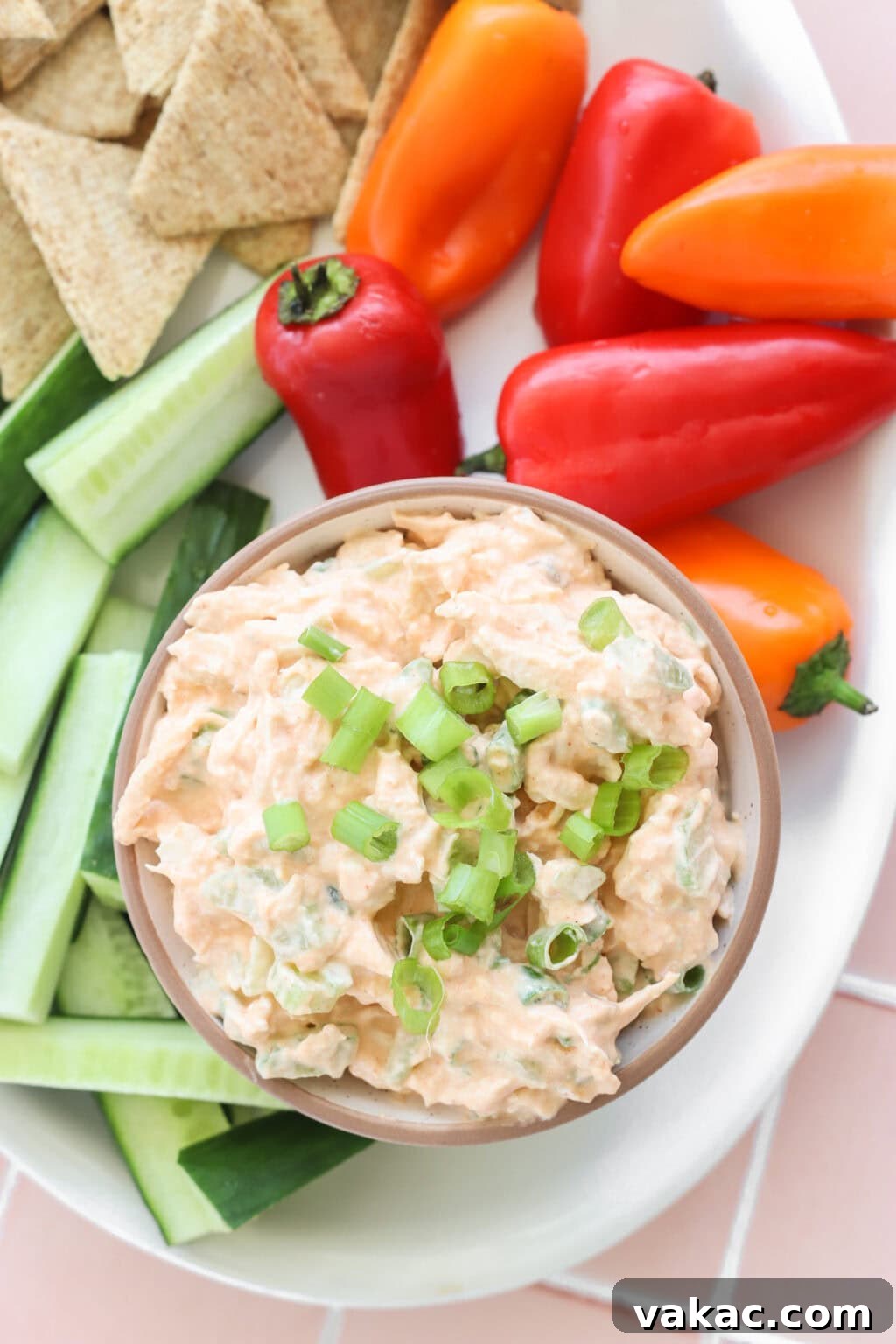 Fast Protein-Packed Buffalo Chicken Salad with Greek Yogurt 6 Quick Buffalo Chicken Salad with Greek Yogurt in a glass bowl on a white serving tray with celery, peppers, and crackers on the side