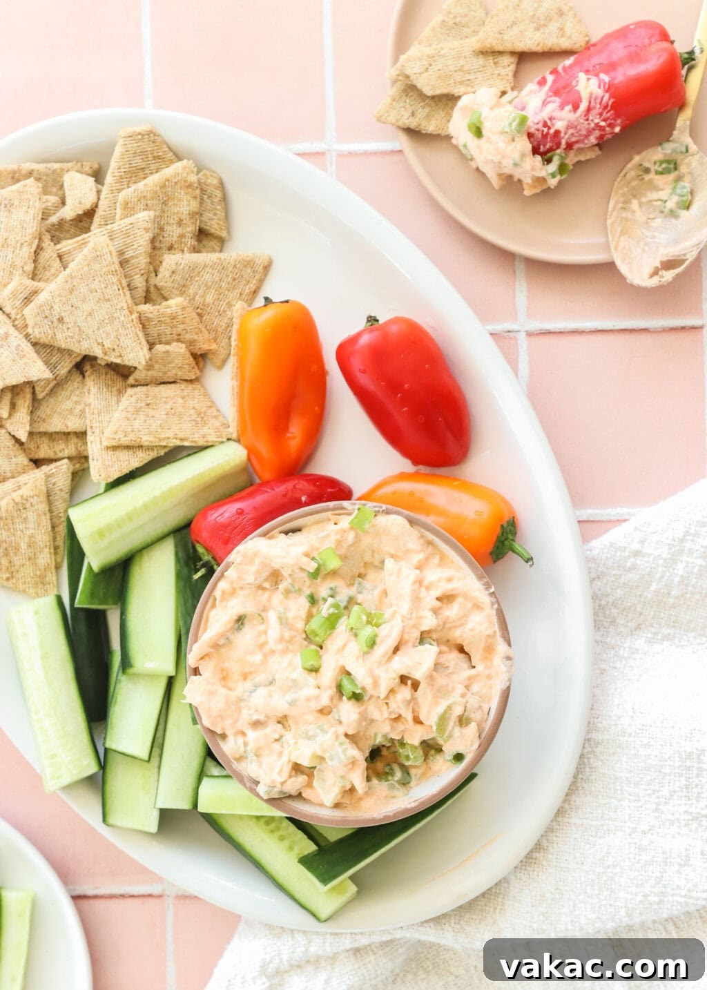 Fast Protein-Packed Buffalo Chicken Salad with Greek Yogurt 8 Quick Buffalo Chicken Salad with Greek Yogurt in a glass bowl on a white serving tray with celery, peppers, and crackers on the side