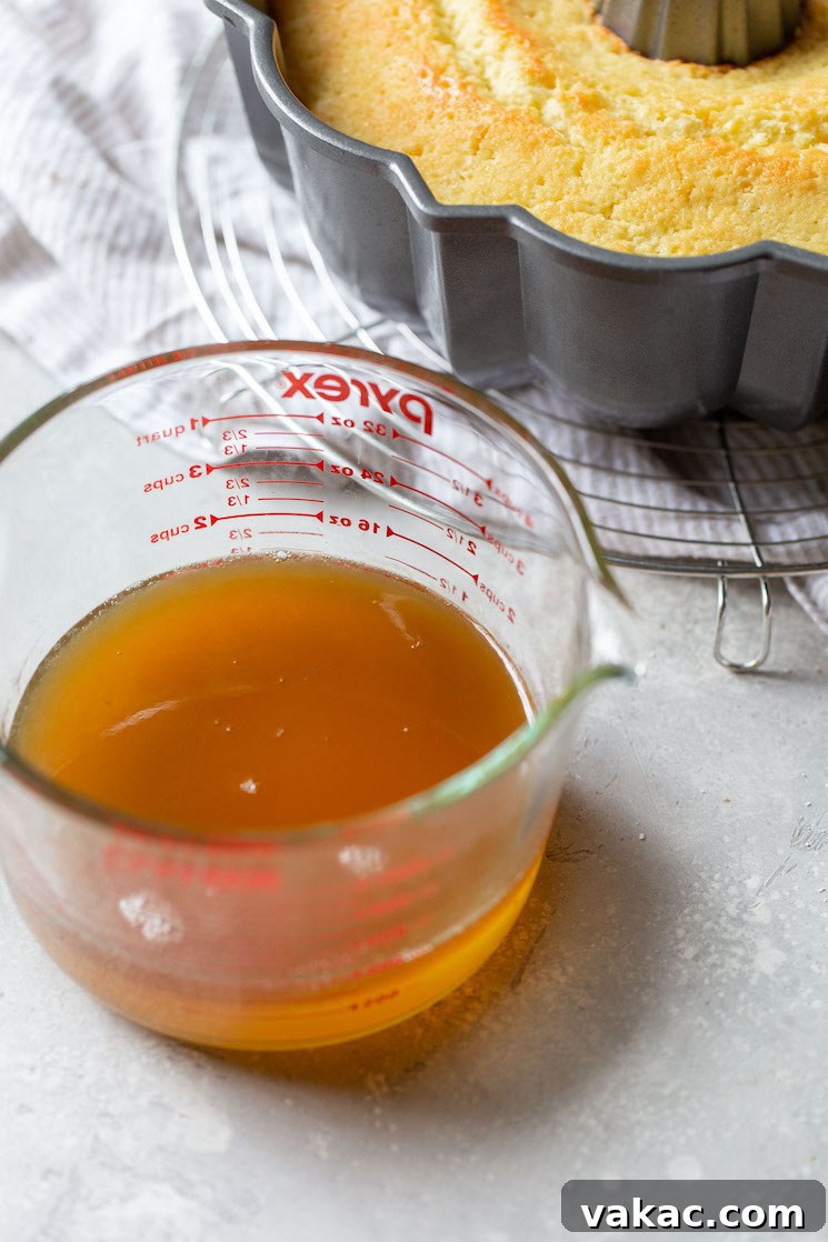 Golden Rum Cake Delight 4 A glass measuring cup holding the rum syrup.