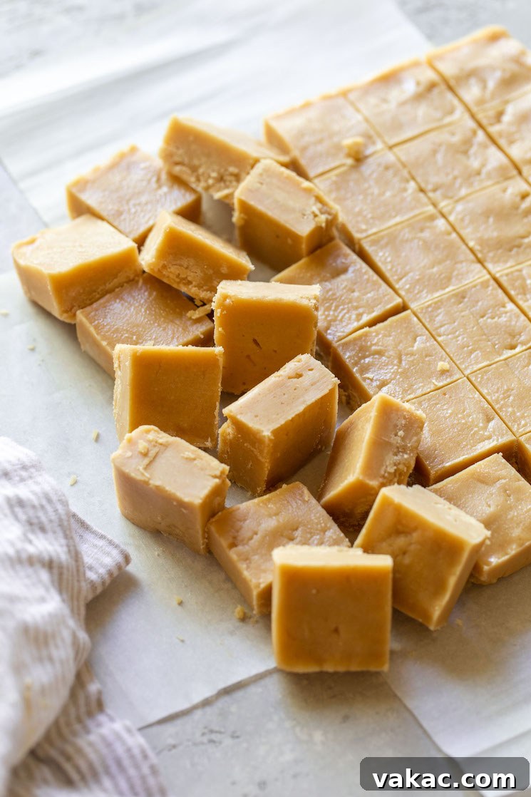 Ultimate Peanut Butter Fudge 5 Peanut butter fudge cut into pieces on parchment paper.