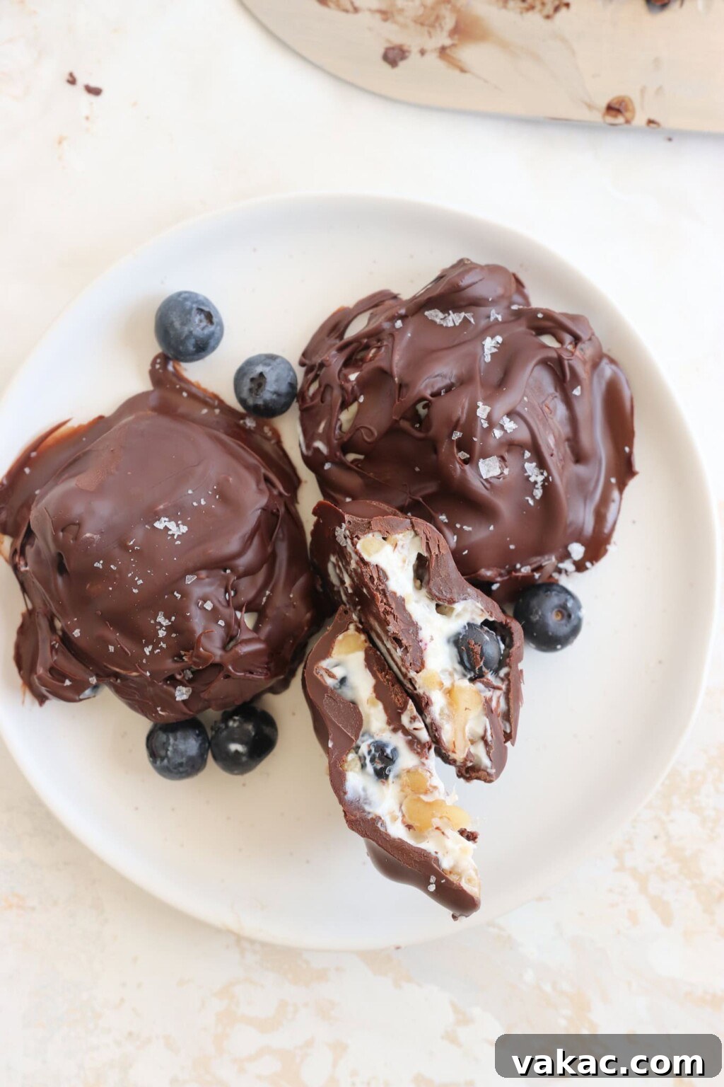Effortless High-Protein Frozen Greek Yogurt Blueberry Bites 9 A white plate of Frozen Blueberry Greek Yogurt Clusters with some loose blueberries